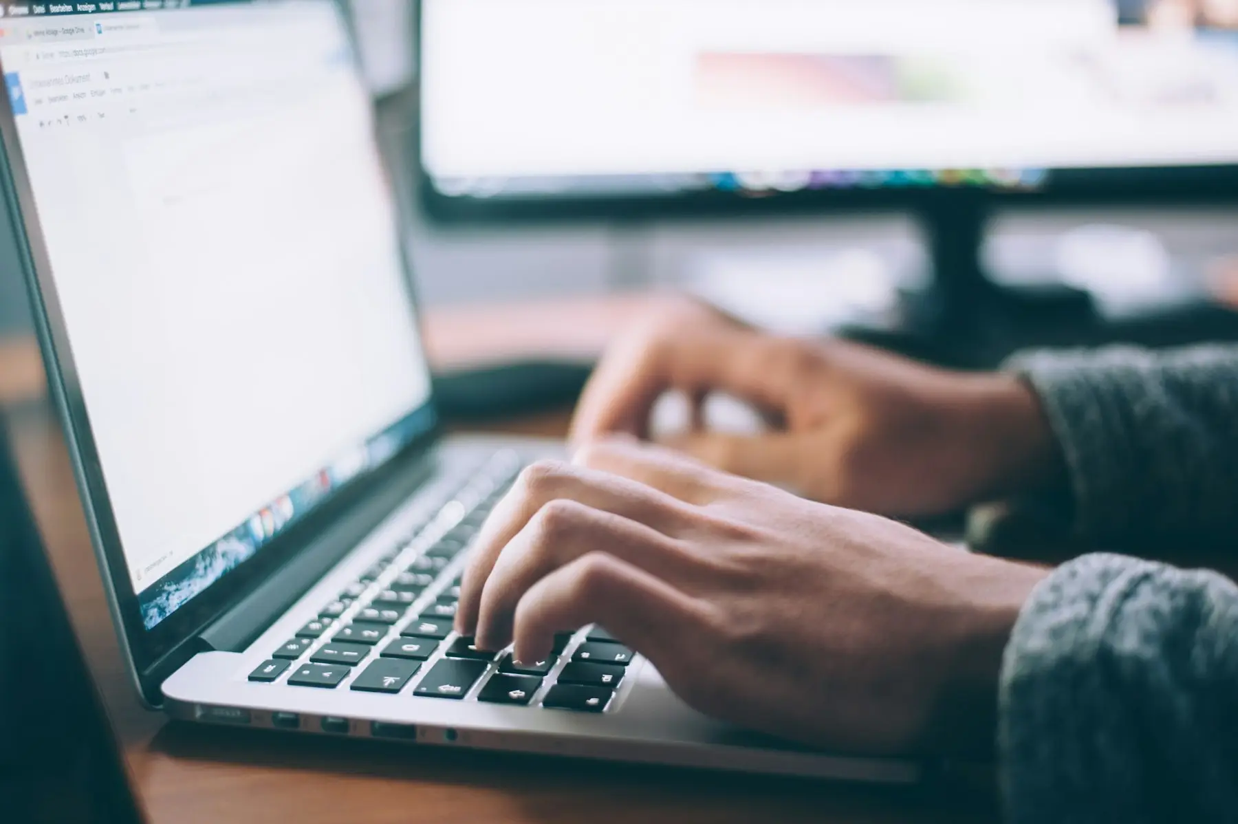 Hände tippen auf einer Laptop-Tastatur