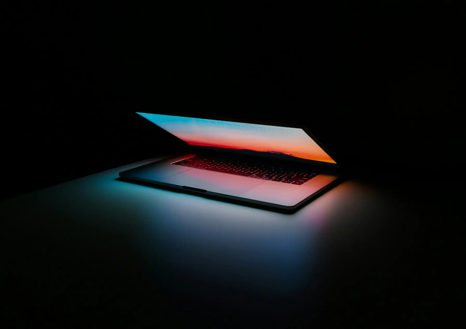 Halb geöffneter Laptop im Dunkeln